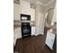 Open kitchen showcasing white cabinets, black appliances, and hardwood floors at 3144 La Costa Way, Raleigh, NC 27610