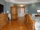 Primary bedroom with hardwood floors, armoire, dresser, and soft grey walls at 325 Sandy Ridge Rd, Dunn, NC 28334