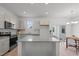 Modern kitchen with gray cabinets, stainless steel appliances, island, and a view to the outdoor patio at 366 Tormore Dr, Sanford, NC 27330