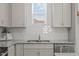 Detailed view of kitchen with granite counters, tiled backsplash, stainless steel sink, and modern dishwasher at 366 Tormore Dr, Sanford, NC 27330
