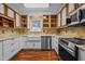 Modern kitchen with white cabinets, stone backsplash, and stainless steel appliances for a contemporary living experience at 3738 Lindsey Woods Rd, Hillsborough, NC 27278