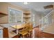 A cozy kitchen with built-in banquette seating, shelving, and a view of the staircase and backyard at 3738 Lindsey Woods Rd, Hillsborough, NC 27278