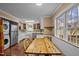 Sunlit eat-in kitchen featuring a farmhouse sink, stainless steel appliances, and wooden dining table with bench seating at 3738 Lindsey Woods Rd, Hillsborough, NC 27278