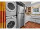Efficient kitchen space featuring stainless steel appliances, ample white cabinetry, and a stacked washer/dryer at 3738 Lindsey Woods Rd, Hillsborough, NC 27278