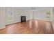 Cozy living room featuring a fireplace, hardwood floors, and natural light from the windows at 3738 Lindsey Woods Rd, Hillsborough, NC 27278