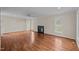 Spacious living room with hardwood floors, a fireplace, and plenty of natural light from large windows at 3738 Lindsey Woods Rd, Hillsborough, NC 27278