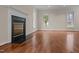 Comfortable living room featuring hardwood floors, a fireplace, and large windows at 3738 Lindsey Woods Rd, Hillsborough, NC 27278