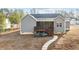 Rear exterior showcasing screened-in porch with deck, steps to the yard, and walkway leading to a stone patio area at 40 Cinnamon Teal Way, Youngsville, NC 27596