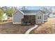 Rear exterior showcasing screened-in porch with deck, steps to the yard, and walkway leading to a stone patio area at 40 Cinnamon Teal Way, Youngsville, NC 27596