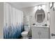 Well-lit bathroom with shower, toilet, vanity, mirror, and decorative details at 40 Cinnamon Teal Way, Youngsville, NC 27596