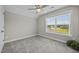 Bright bedroom with neutral walls, plush carpeting, a ceiling fan, and a window overlooking the yard at 40 Cinnamon Teal Way, Youngsville, NC 27596