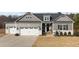 Charming home with a three-car garage, elegant gray siding, and stone accents for enhanced curb appeal at 40 Cinnamon Teal Way, Youngsville, NC 27596