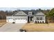Charming home with a three-car garage, elegant gray siding, and stone accents for enhanced curb appeal at 40 Cinnamon Teal Way, Youngsville, NC 27596