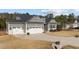 Charming home featuring gray siding, a spacious driveway, and a two-car garage with decorative pergola accents at 40 Cinnamon Teal Way, Youngsville, NC 27596