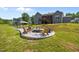 Cozy fire pit area with stylish seating, surrounded by lush green lawns and landscaping, ideal for outdoor gatherings at 40 Cinnamon Teal Way, Youngsville, NC 27596