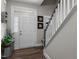Inviting foyer with wood floors, white door and staircase, and decorative plants at 40 Cinnamon Teal Way, Youngsville, NC 27596
