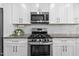 Close-up of the kitchen featuring stainless steel oven, microwave and white subway tile backsplash at 40 Cinnamon Teal Way, Youngsville, NC 27596