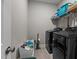 Efficient laundry room with dark gray washer and dryer and storage shelves at 40 Cinnamon Teal Way, Youngsville, NC 27596