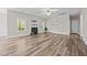 Expansive living room with hardwood floors, fireplace, large windows, and a ceiling fan at 40 Cinnamon Teal Way, Youngsville, NC 27596