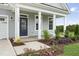 Charming front porch with blue door, white columns, landscaping, and neutral gray siding at 40 Eagle Crest Ct # Clayton Low Country, Lillington, NC 27546