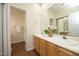A bathroom features a double sink vanity with wood cabinets, decor, and a large mirror at 407 Misty Grove Cir, Morrisville, NC 27560
