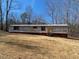 Exterior view of a single-story mobile home with yard and blue sky at 415 Island Creek Estates Rd, Henderson, NC 27537