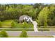Aerial view of a white brick home, mature trees, and a sprawling green lawn at 5040 Shakori Trl, Chapel Hill, NC 27707