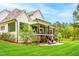Large backyard with covered deck, patio seating area, and well-maintained lawn surrounded by mature trees at 5040 Shakori Trl, Chapel Hill, NC 27707