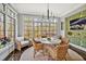 Cozy breakfast nook with wicker seating, a round table, and natural light from the surrounding windows at 5040 Shakori Trl, Chapel Hill, NC 27707