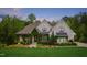 Inviting two-story home with painted brick, manicured landscaping, and unique greenery covered entrance at 5040 Shakori Trl, Chapel Hill, NC 27707