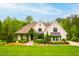 Charming two-story home featuring painted brick, lush landscaping, and a welcoming front porch at 5040 Shakori Trl, Chapel Hill, NC 27707