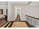 Bright hallway with dark hardwood floors, modern railing, and view to a living area with white sofa at 5040 Shakori Trl, Chapel Hill, NC 27707