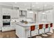 A modern kitchen showcasing a spacious island with seating, sleek appliances, and white cabinetry at 5040 Shakori Trl, Chapel Hill, NC 27707