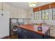 Well-lit laundry room with appliances, ample counter space, and a central island at 5040 Shakori Trl, Chapel Hill, NC 27707