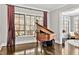 Bright living room showcasing a grand piano and large windows overlooking the outdoor living space at 5040 Shakori Trl, Chapel Hill, NC 27707