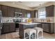 Well-lit kitchen features stainless steel appliances, a kitchen island with bar seating, and gray cabinets at 505 Marthas View Way, Wake Forest, NC 27587
