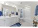 Well-lit bathroom with double sinks, a large mirror, and a bathtub/shower combo at 509 Marthas View Way, Wake Forest, NC 27587