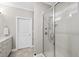 Bright bathroom featuring a large glass-enclosed shower and white cabinets and doors at 510 Mariah Towns Way, Garner, NC 27529
