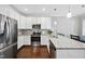 Well-lit kitchen with stainless steel appliances, white cabinets, hardwood floors and eat in breakfast area at 510 Mariah Towns Way, Garner, NC 27529