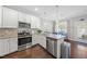 Modern kitchen boasts white cabinetry, granite countertops, stainless steel appliances, and a breakfast bar at 510 Mariah Towns Way, Garner, NC 27529