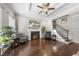 Inviting living room with a fireplace, TV, ceiling fan, hardwood floors and staircase to the second floor at 510 Mariah Towns Way, Garner, NC 27529