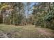 View of grass-covered backyard with mature trees at 5613 Ashton Dr, Raleigh, NC 27612