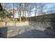 Spacious backyard with stone retaining wall and stamped concrete patio at 5819 Windham Dr, Raleigh, NC 27609