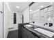 Modern bathroom with dual sinks, marble walls, black fixtures, and glass-enclosed shower at 5819 Windham Dr, Raleigh, NC 27609