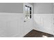 Bright entryway with hardwood floors, white wainscoting, and door with glass panel insert at 5819 Windham Dr, Raleigh, NC 27609