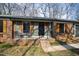 Close-up of a brick home's charming front porch with seating, shutters, and inviting curb appeal at 5819 Windham Dr, Raleigh, NC 27609