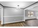 Bright living room features hardwood floors, stylish lighting, and access to other rooms at 5819 Windham Dr, Raleigh, NC 27609