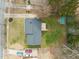 Aerial view shows the house, cars in the driveway, deck, and storage shed at 5913 North Hills Dr, Raleigh, NC 27609