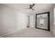 Empty bedroom with carpet floors, ceiling fan, closet and large mirror at 5913 North Hills Dr, Raleigh, NC 27609
