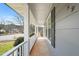 Inviting covered front porch with white pillars and a view of the street at 5913 North Hills Dr, Raleigh, NC 27609